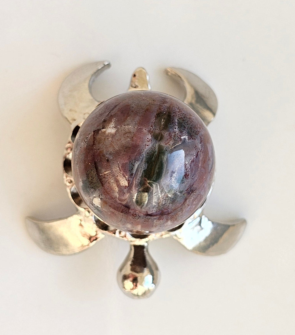 small ocean jasper sphere on a turtle sphere stand